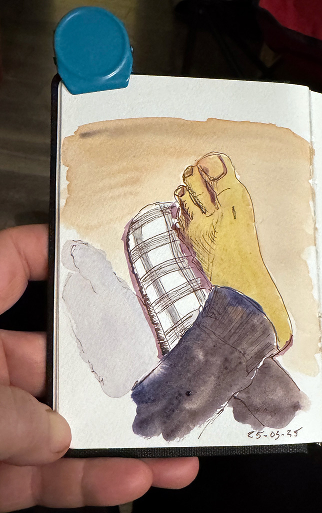 Line and wash sketch. My feet crossed at the ankle. One foot is bare. The other is in a checkered white and grey slipper.