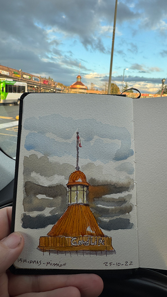 Line and wash sketch. A dome in copper, with a cuppola on top. grey and white clouds and a bit of blue sky. The image is a photo of the sketchbook held in one hand, showing the subject in the back 