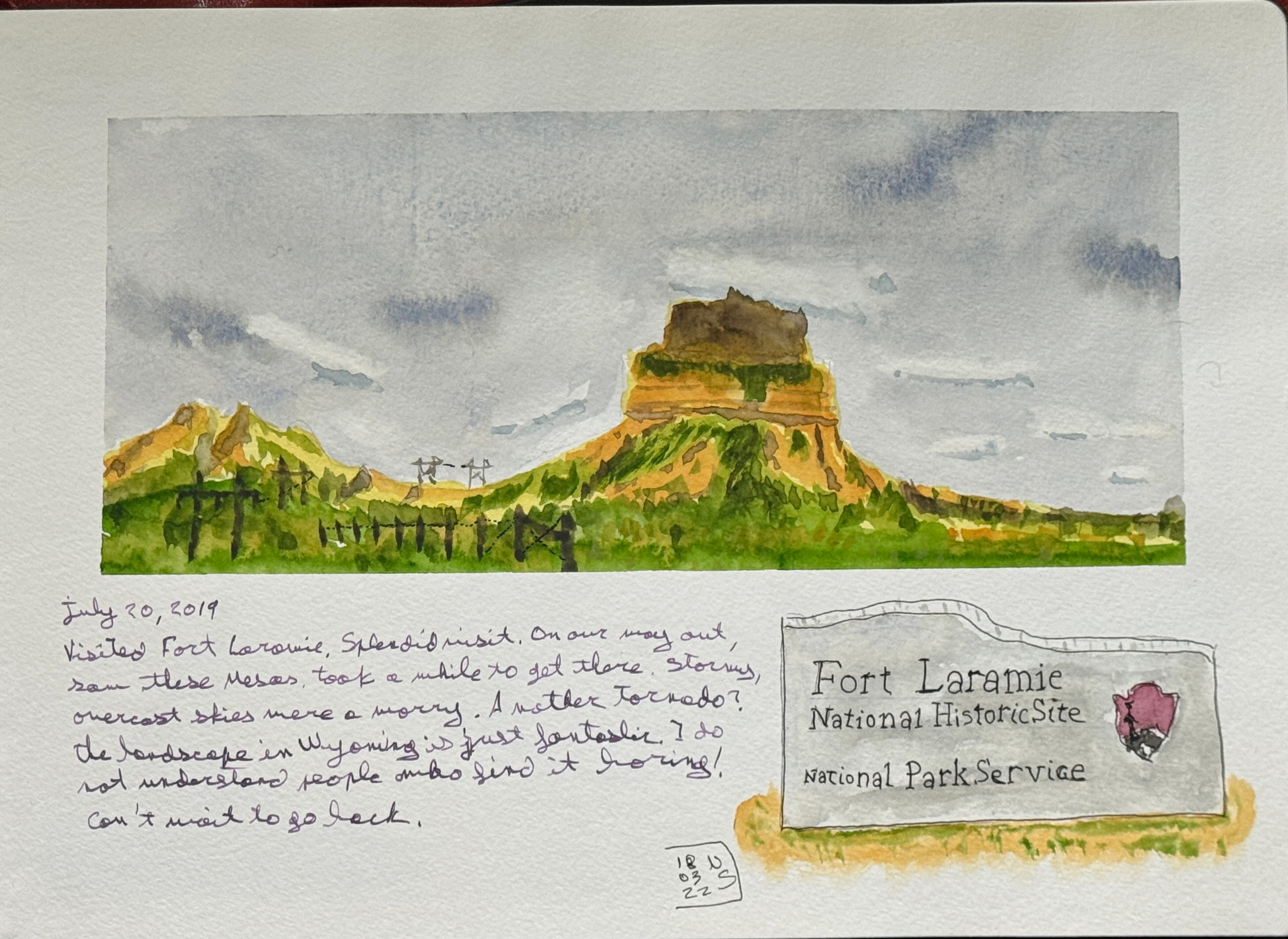 Line and wash sketch. A landscape of a mesa in Wyoming. There is a cartouche drawing of the stone marker at the entrance of Fort Laramie. A handwritten note says July 20, 2019. Visited Fort LarAmie, splendid nisit, On our may out, saw these Mesas. Took a mhile to get here. Stormy, overcast skies were a worry. Another tornado? The landscape in Wyoming is just fantastic. I do understand people who find it boring! Can't wait to go back.